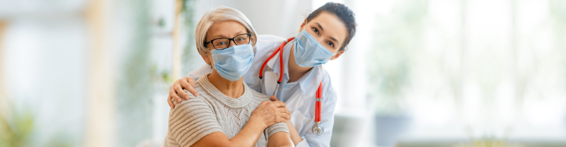 patient and doctor wearing face masks and smiling