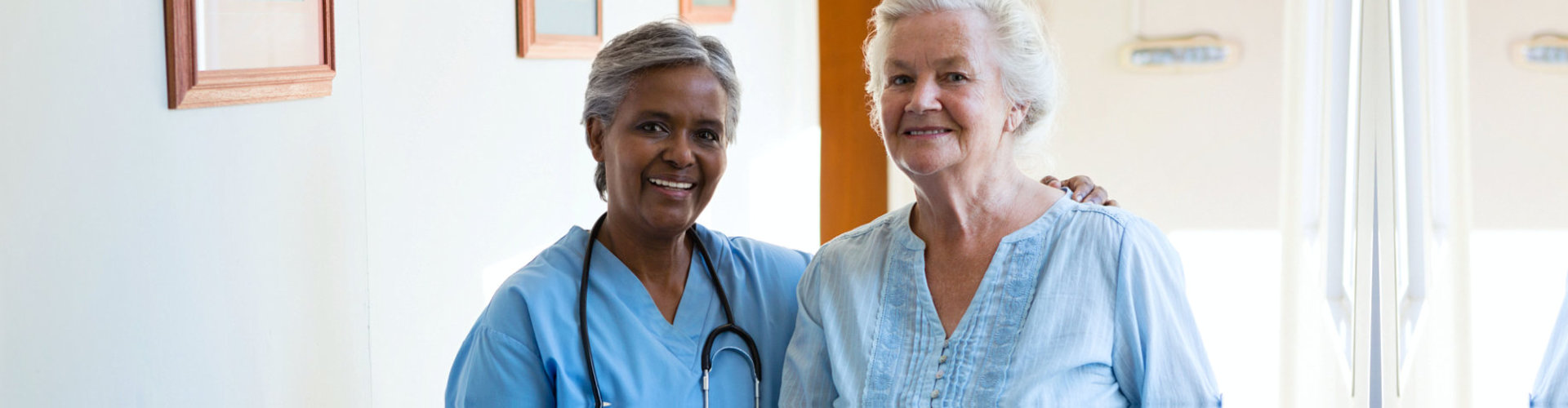 adult nurse and elderly patient posing
