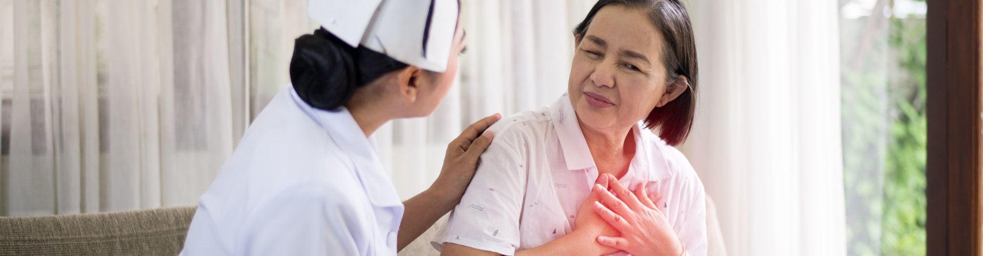 nurse aiding elderly suffering from chest pain